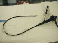 Figur 2   Olympus gastroskop p&aring;montert suturutstyr: suturkapsel (p&aring; tuppen) og man&oslash;verh&aring;ndtak