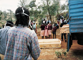 Likene er blitt gravd opp og lagt i kister, klare til &aring; kj&oslash;res til Nairobi. Barna som biv&aring;ner er if&oslash;rt skoleuniformer