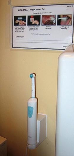 Figur 5  Munnstellkort montert p&aring; badevegg sammen med en elektrisk tannb&oslash;rste
