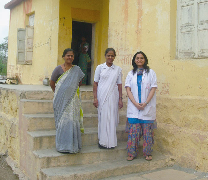 To helsearbeidere og legen (h&oslash;yre) foran helseklinikken i Hiradpuri Village