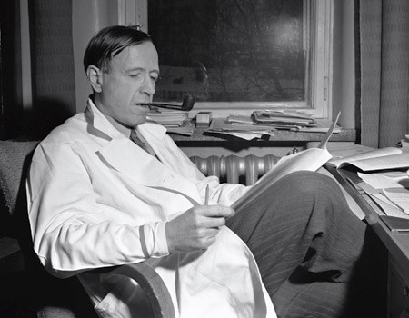 Figur 2  Hans Jacob Ustvedt (1903&thinsp;&ndash;&thinsp;82) fotografert 1.2. 1954 i hvit frakk p&aring; sitt kontor, r&oslash;yker pipe og leser dokumenter&hellip;