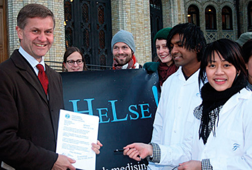 Linda Nguyen overrekker over 1 400 underskrifter p&aring; en minnepinne til Erik Solheim. Foto Knut E. Braaten