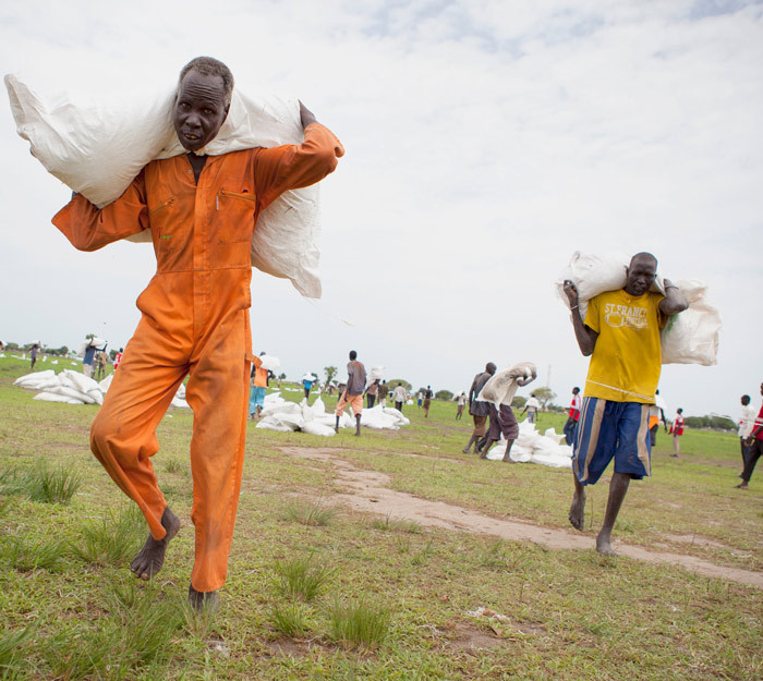 Lokale hjelpearbeidere bringer inn forsyninger. Foto Pawel Krxysiek/ICRC