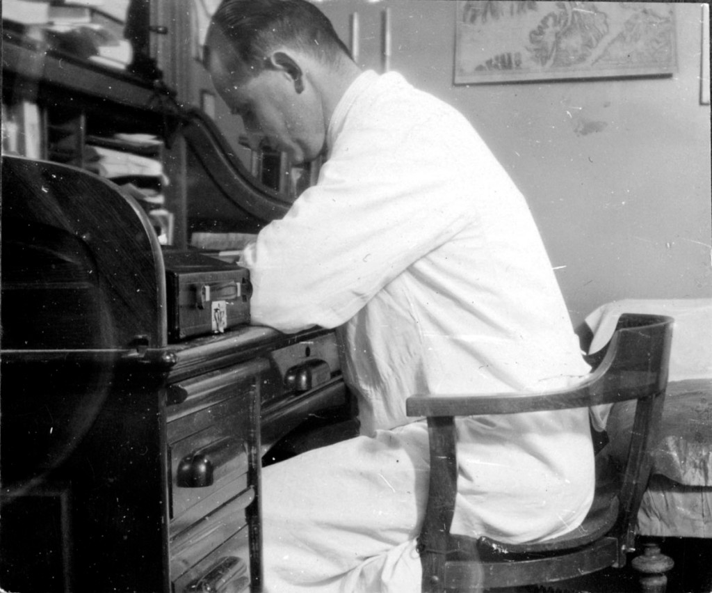 Doktor Johs. H. Lund sittende ved skrivebordet p&aring; kontoret sitt i 1929. Illustrasjonsfoto: Finnmark fylkesbibliotek